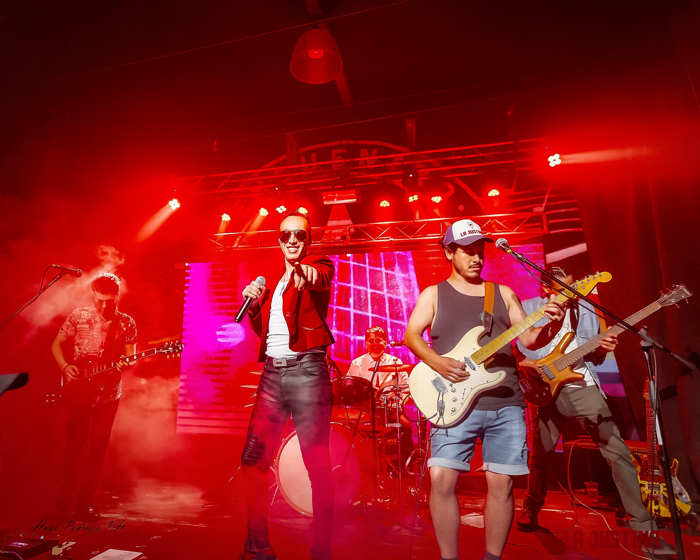 Artista cantando en un escenario con luces rojas
